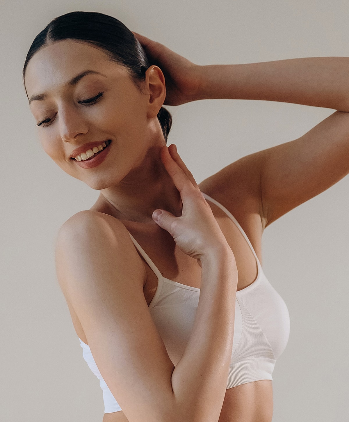 Smiling woman with sleek hair and relaxed pose.