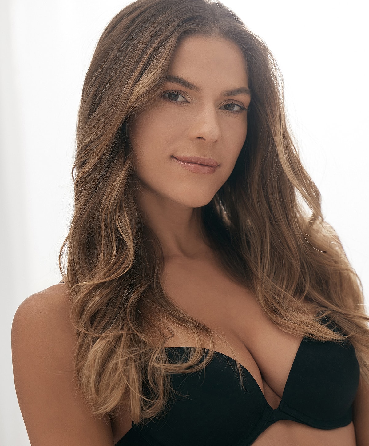 Woman with long hair wearing a black bra.