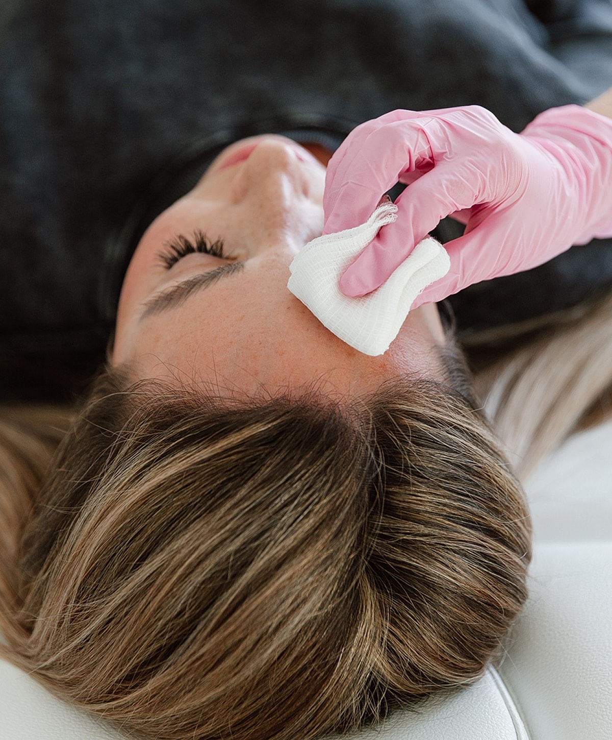 Woman receiving facial treatment with gentle care.