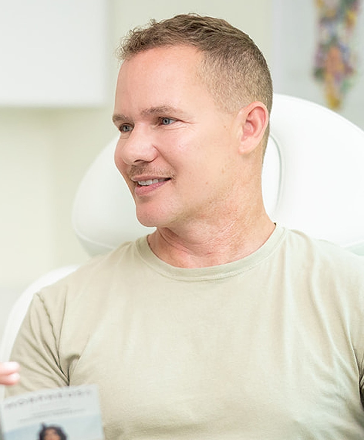 Man smiling in casual setting, engaging conversation.