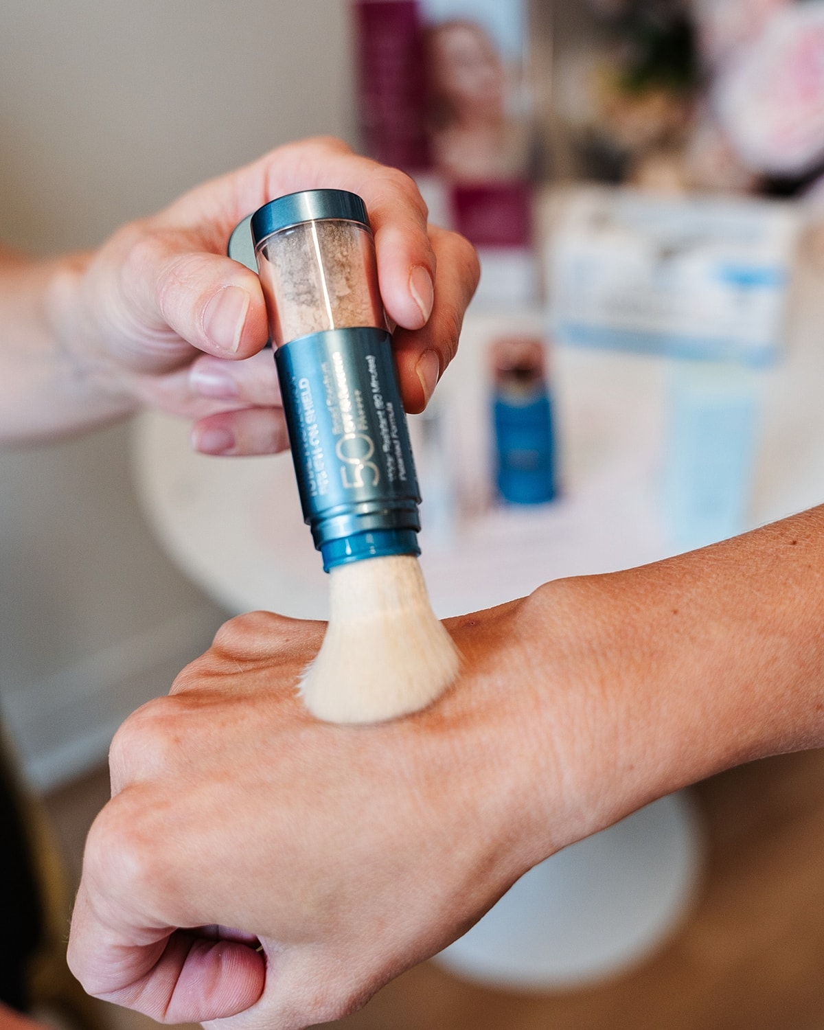 Applying powdered sunscreen with brush applicator.