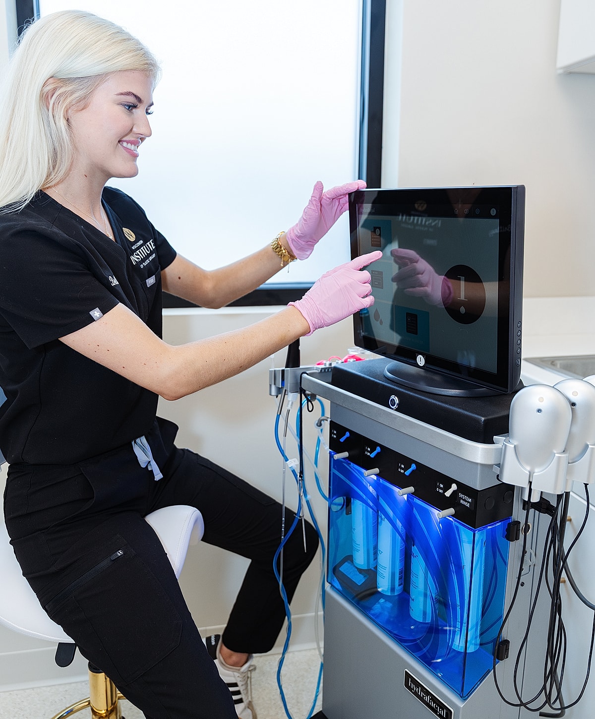 Skincare technician using treatment machine interface.