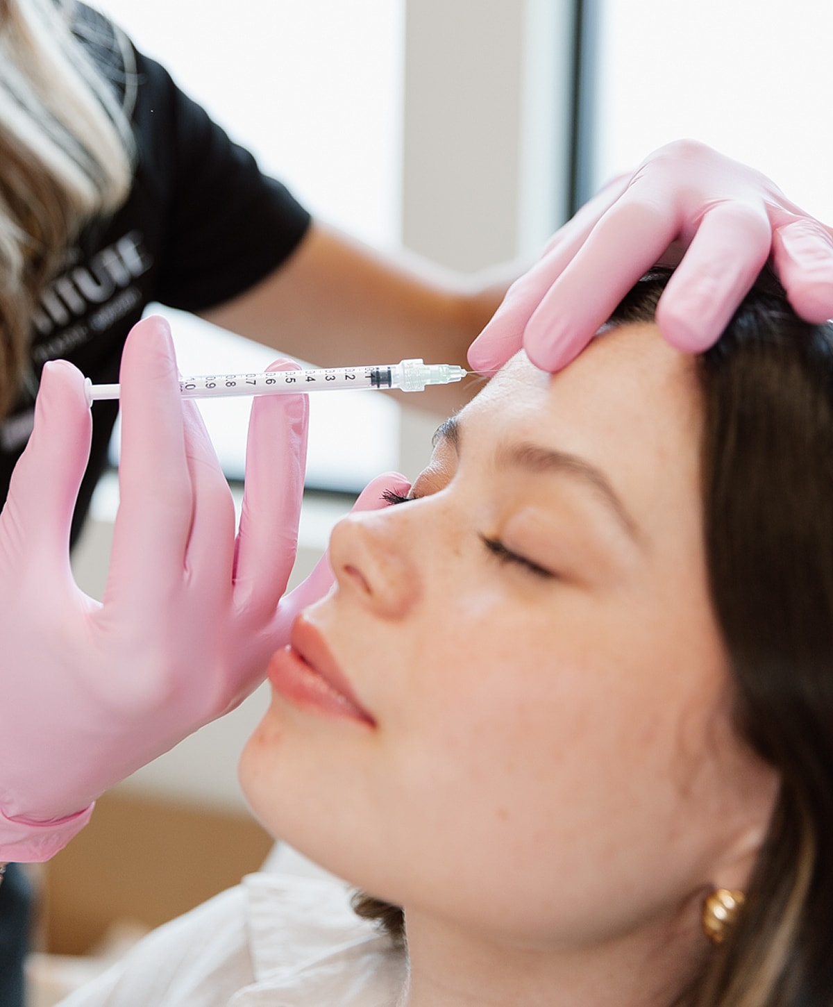 Administering cosmetic injection in a clinic setting.
