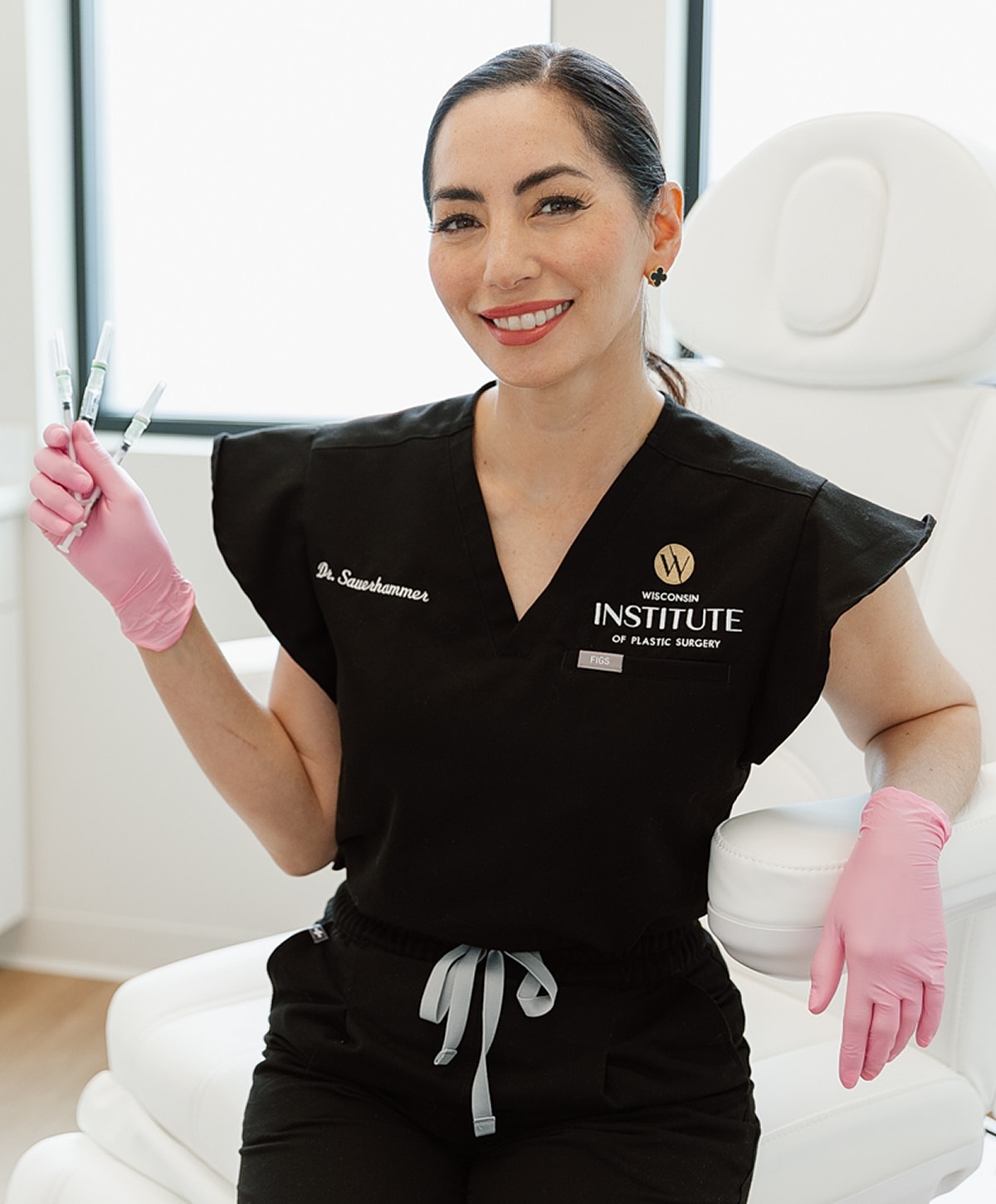 Doctor holding syringes in a clinic setting.