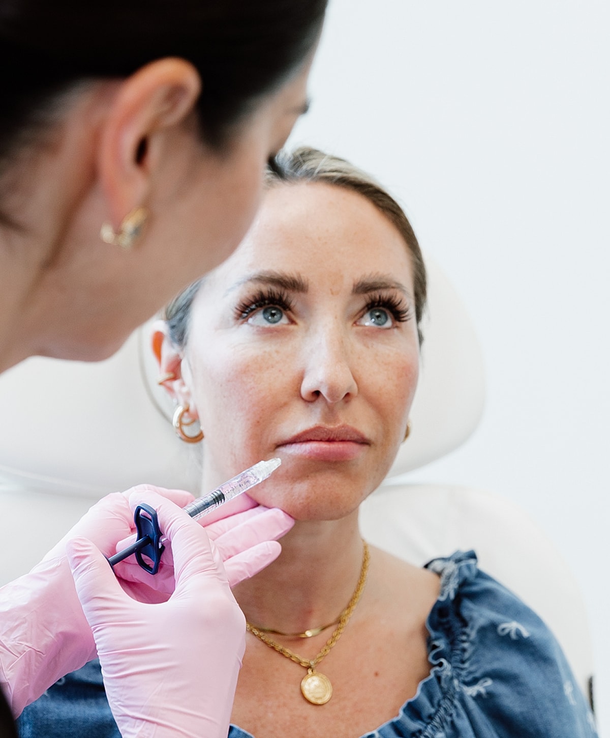 Patient receiving cosmetic injection procedure at clinic.
