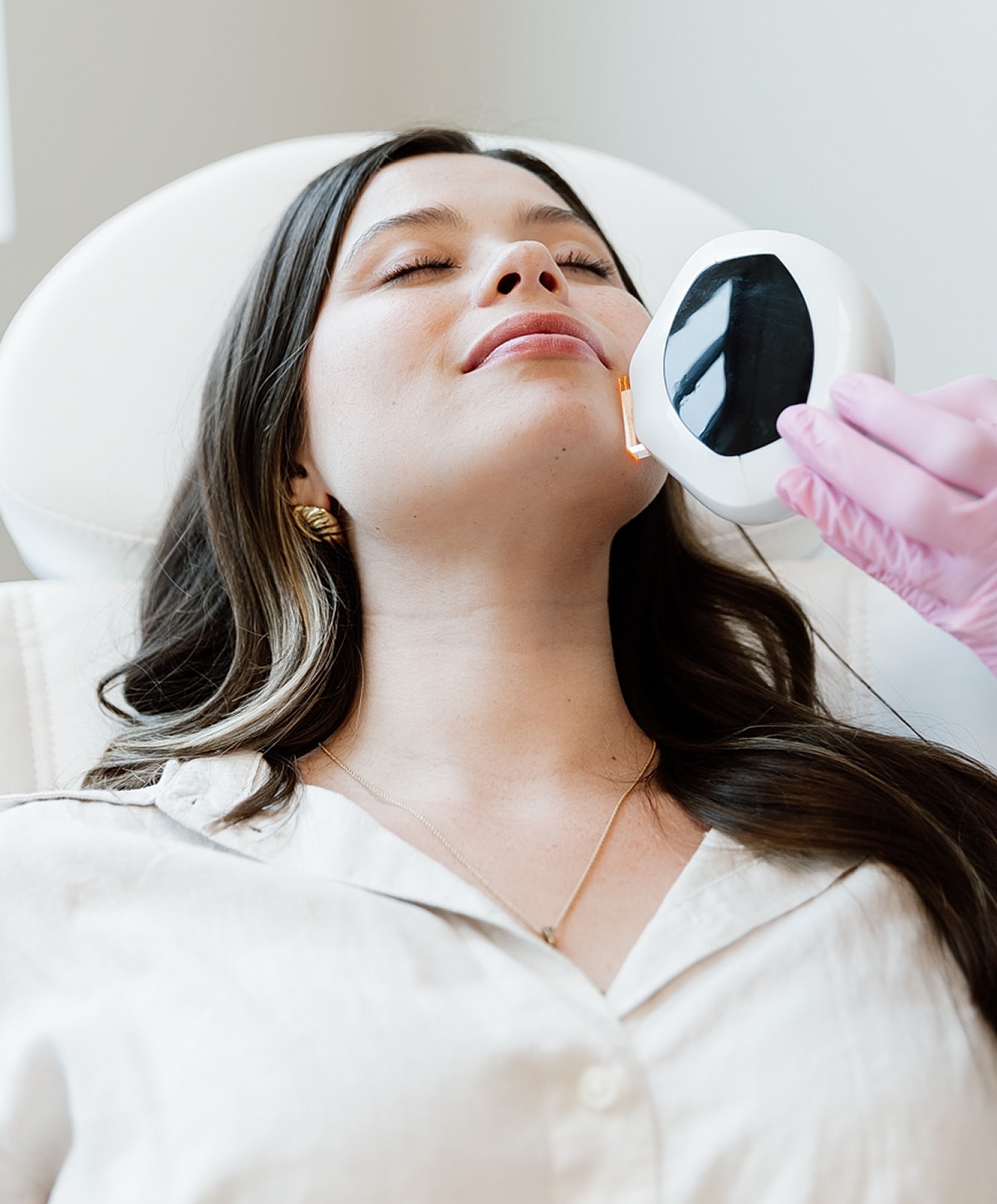 Woman receiving facial treatment in spa setting.
