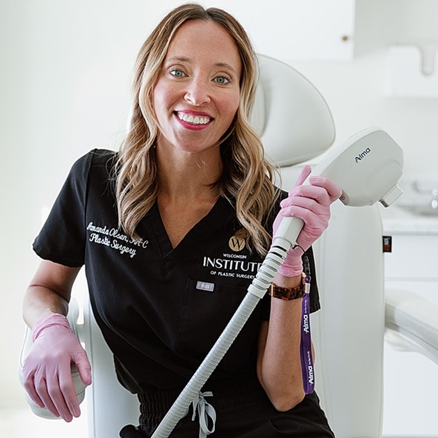 Plastic surgeon smiling in clinic with equipment.
