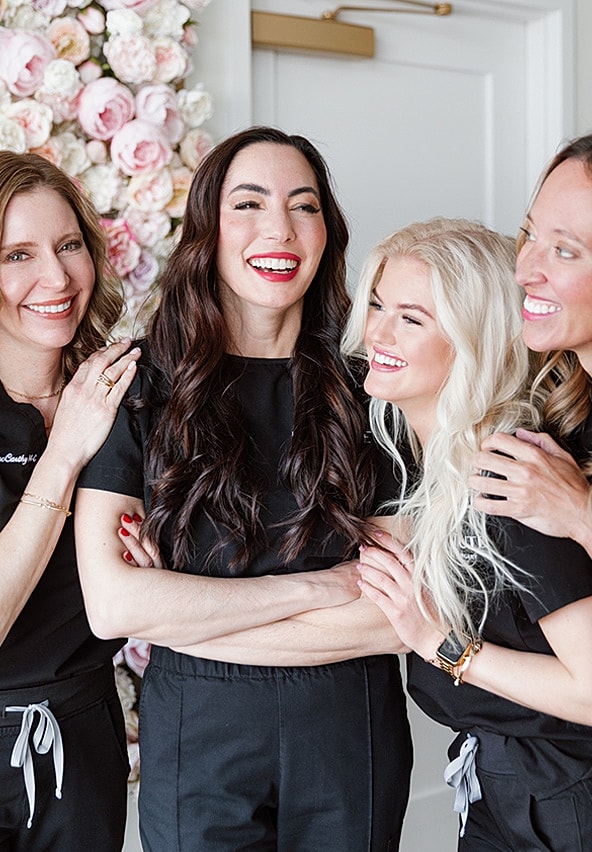 Happy group of four women smiling together.