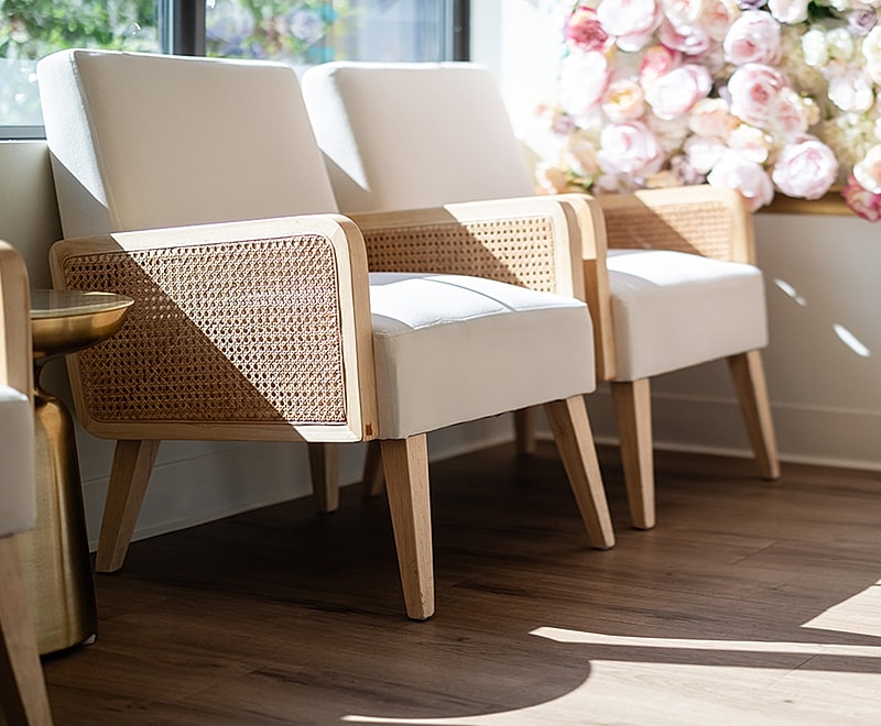 Modern chairs with natural wood accents and flowers.