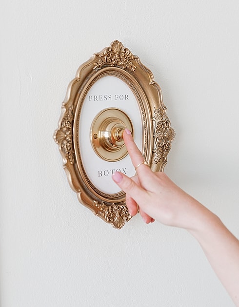 Button labeled "Press for Botox" on wall.