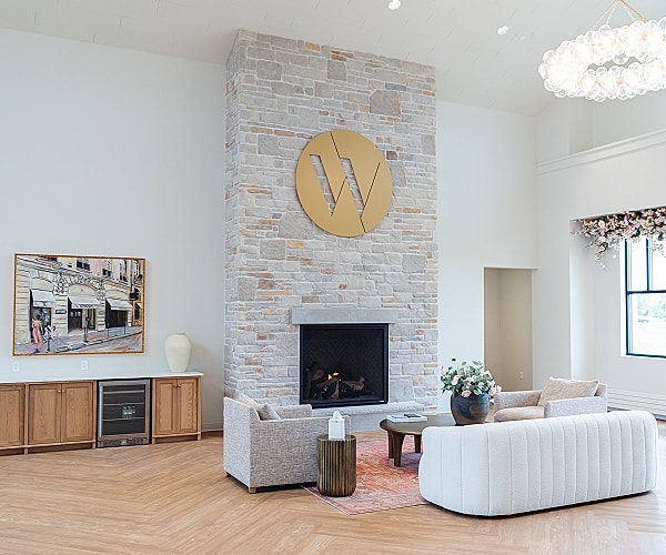 Modern living room with stone fireplace and artwork.