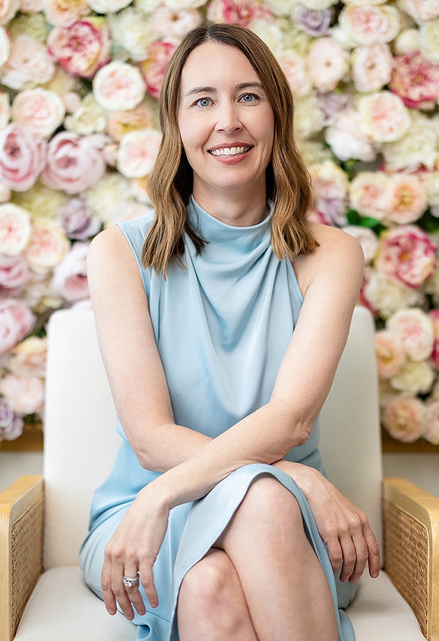 Woman in blue dress posing with floral background