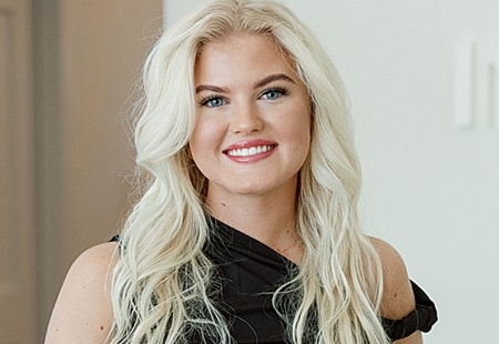 Smiling woman with long, wavy blonde hair.
