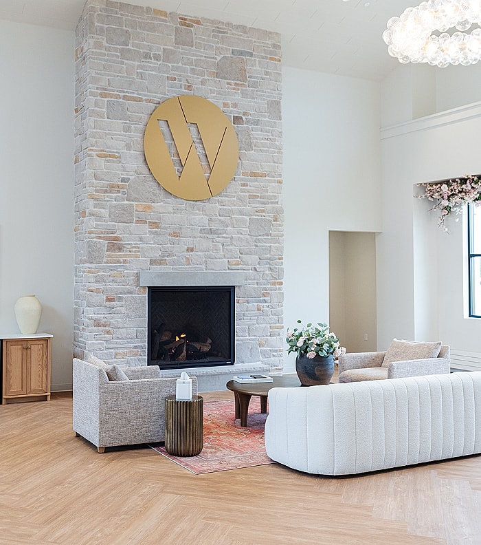 Modern living room with stone fireplace and decor.
