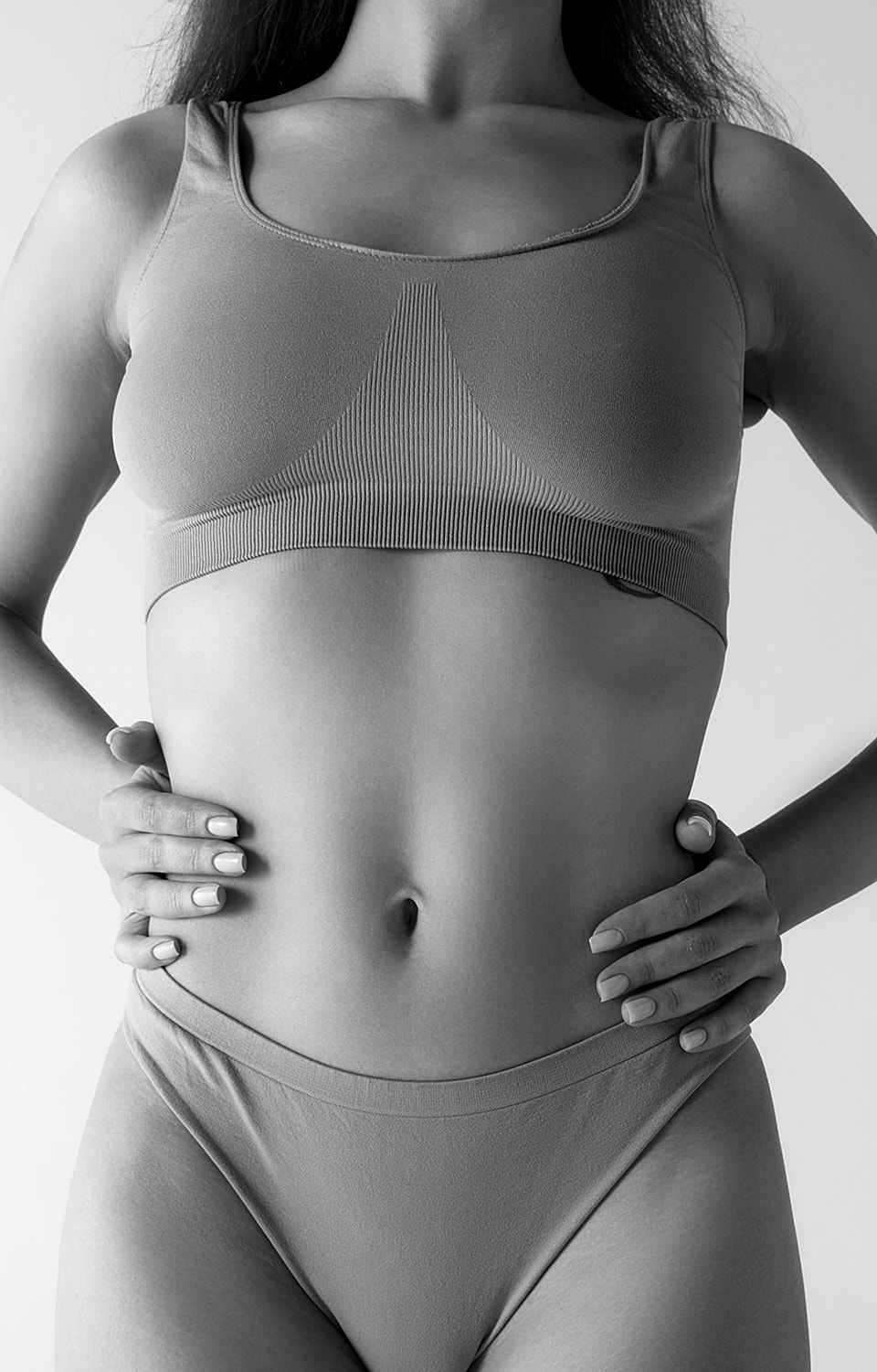Model in crop top and underwear, black and white.