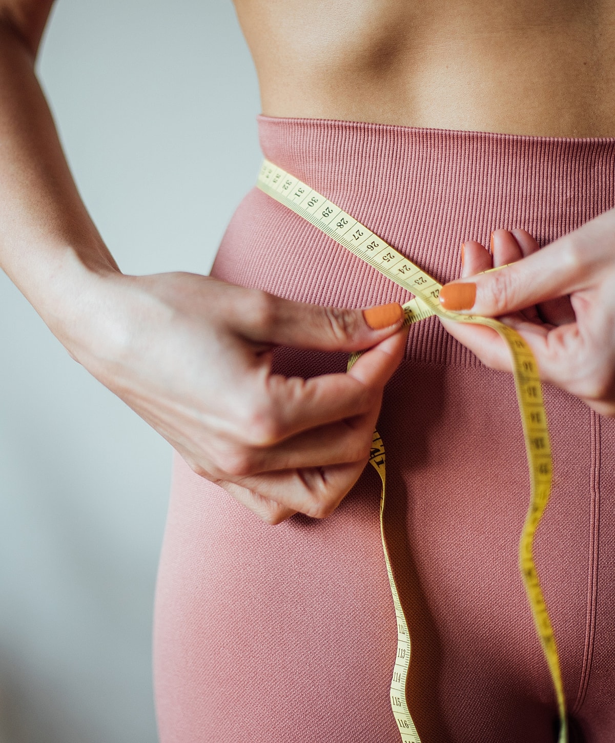 Measuring waist with a measuring tape.