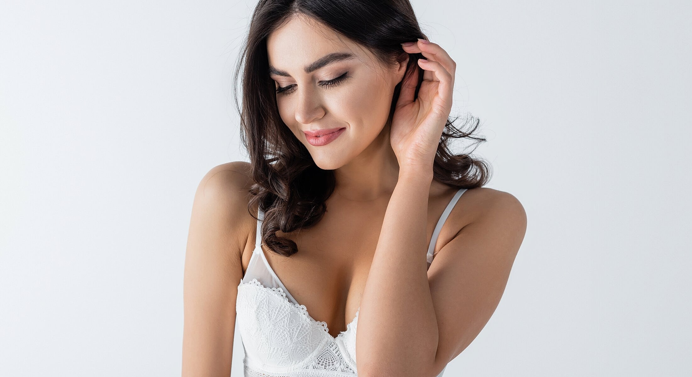 Woman in delicate lingerie with a soft smile.