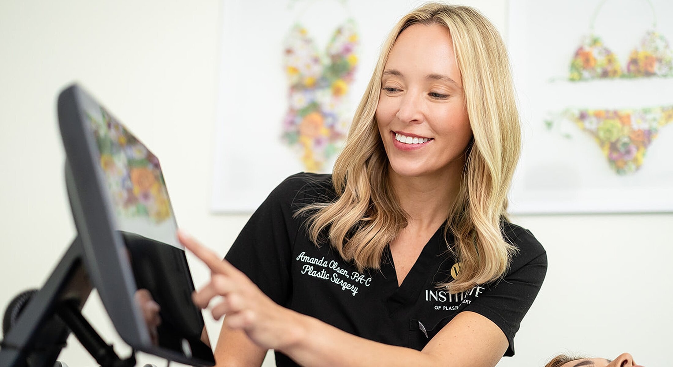 Plastic surgeon interacting with touchscreen interface.