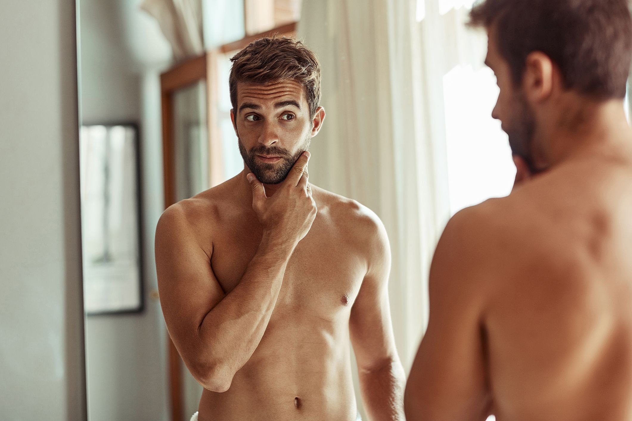 Man grooming in front of a mirror.