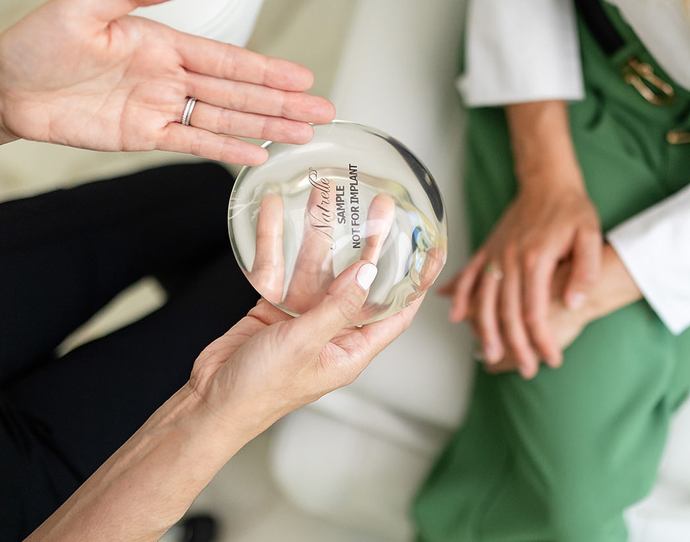 Hands holding a clear sample disc.