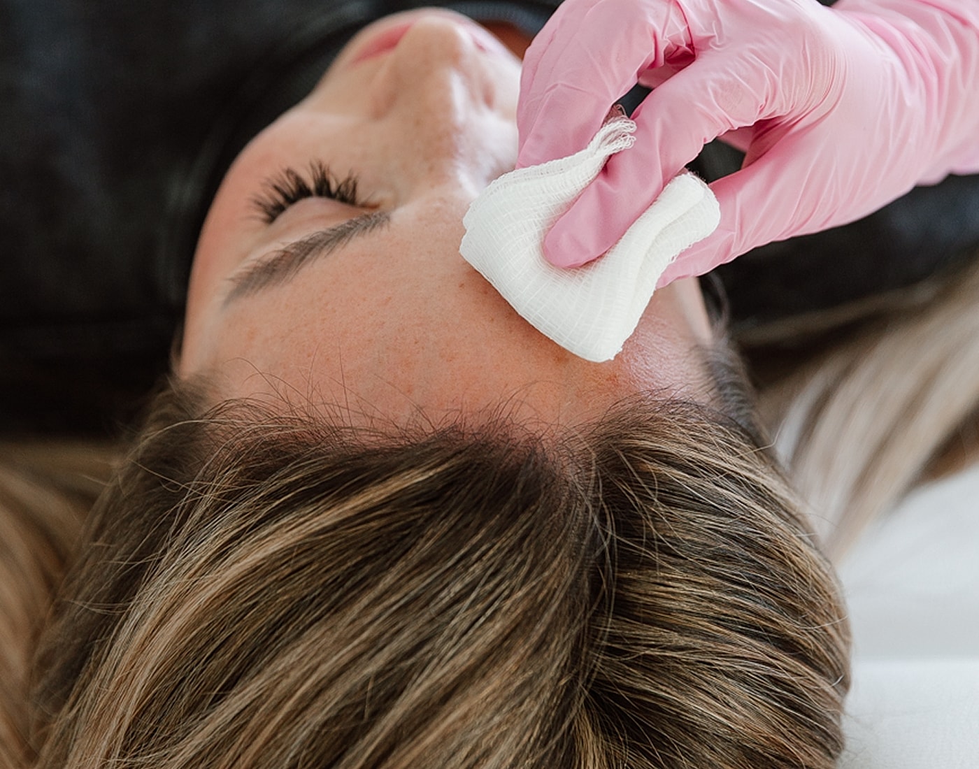 Applying treatment to a person's forehead.